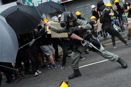 A riot police officer clashes with demonstrators during a protest against the Yuen Long attacks in Yuen Long