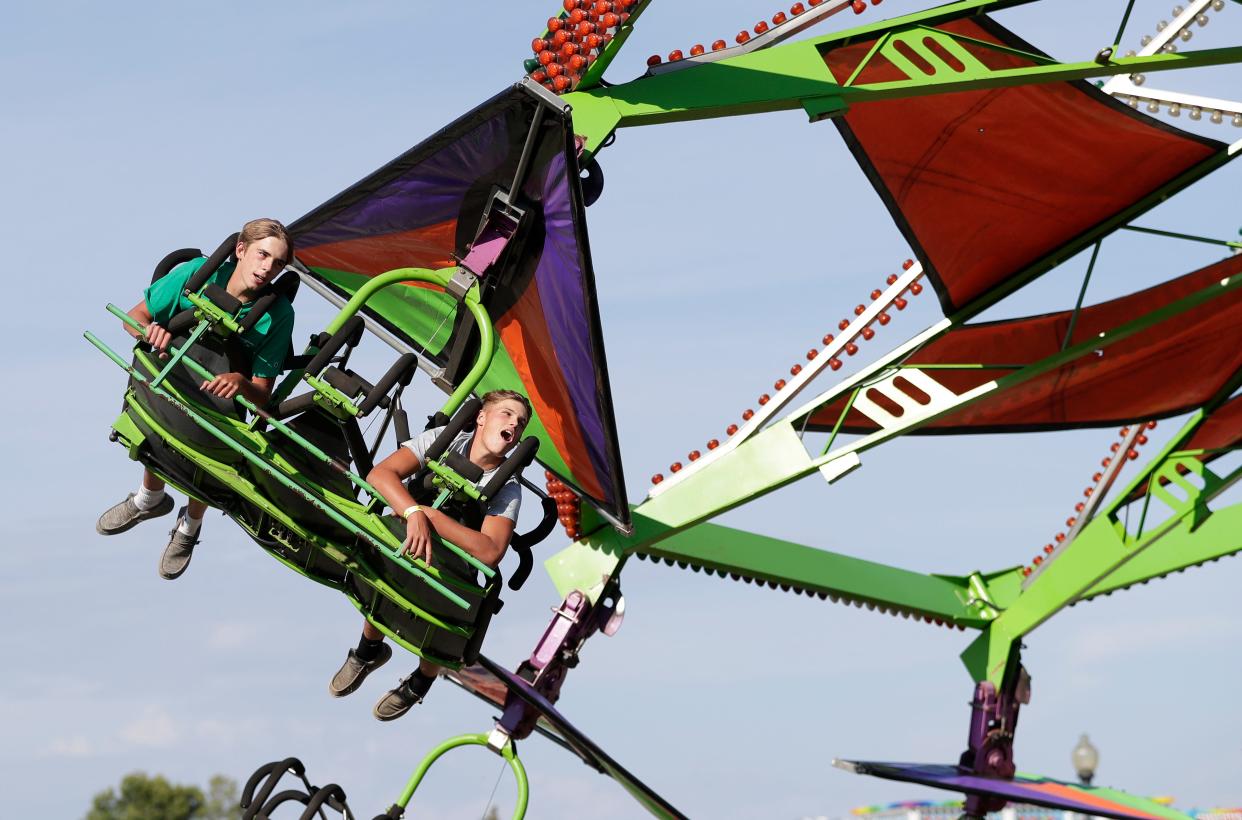 Fairgoers ride the Cliff Hanger at the Brown County Fair on Aug. 19, 2020, in De Pere, Wis.