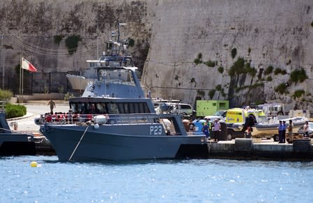 Migrants get ready to disembark from a Maltese Patrol boat after they were transferred from the rescue vessel Alan kurdi, at the maritime base in Pieta