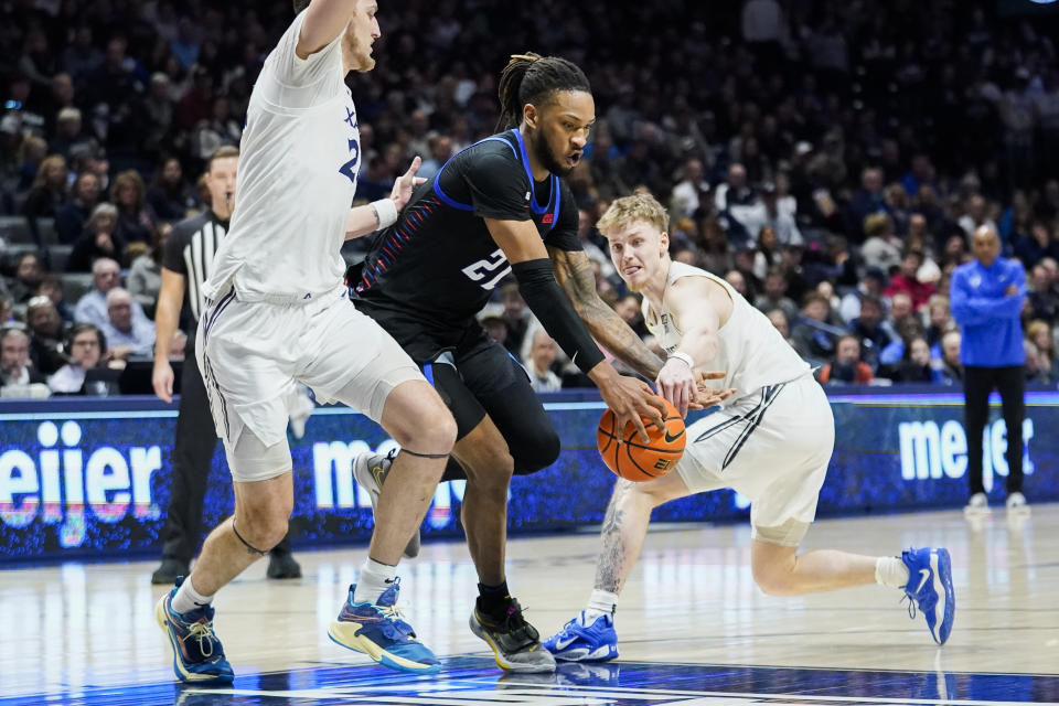 Xavier guard Adam Kunkel, right, knocks the ball away from DePaul forward Da'Sean Nelson (21) as Xavier forward Jack Nunge, left, guards during the first half of an NCAA college basketball game, Saturday, Feb. 18, 2023, in Cincinnati. (AP Photo/Joshua A. Bickel)