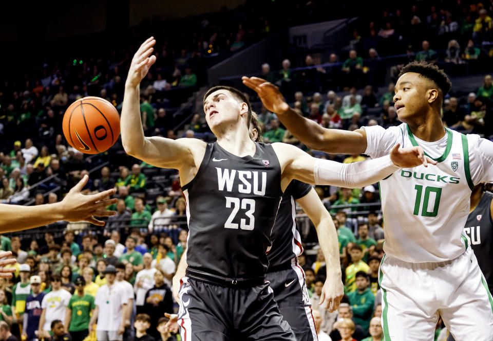 Washington State forward Andrej Jakimovski (23) and Oregon forward Kwame Evans Jr. (10) go for a rebound during the first half of an NCAA college basketball game in Eugene, Ore., Saturday, Feb. 10, 2024. (AP Photo/Thomas Boyd)