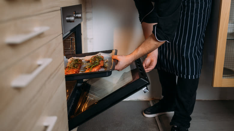 Person placing meat in oven