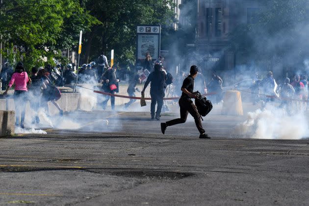 Demonstrators are running as Montreal Police uses tear gas during a march against police brutality and racism in Montreal, Canada, on June 7, 2020. 