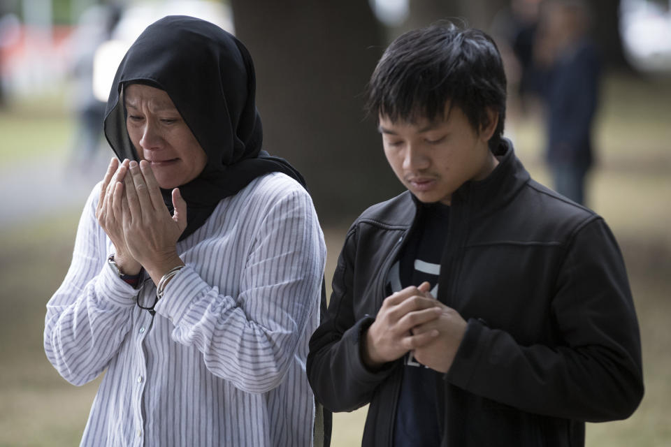 Mourners react at a memorial site for victims in last week's mass shooting near the Al Noor mosque in Christchurch, New Zealand, Tuesday, March 19, 2019. Streets near the hospital that had been closed for four days reopened to traffic as relatives and friends of the victims of last week's shootings continued to stream in from around the world. (AP Photo/Vincent Thian)