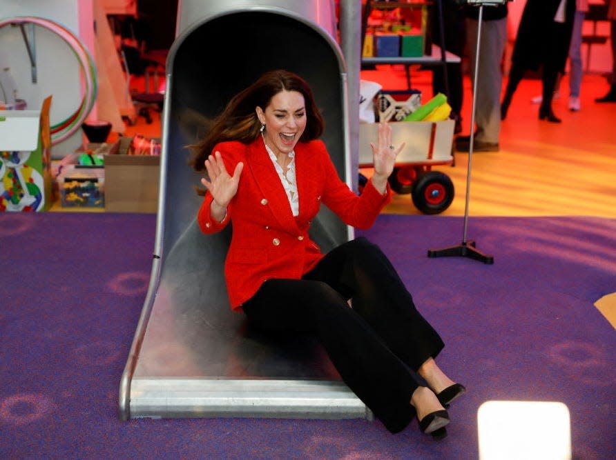 Kate Middleton slides down a slide wearing a red blazer in Denmark