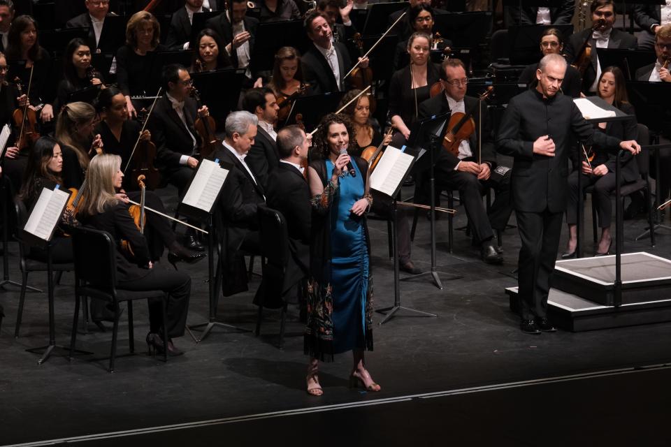 Composer Sarah Gibson talks to the audience at the Van Wezel Performing Arts Hall about the world premiere of her piece “to make this mountain taller” at the Sarasota Orchestra, with guest conductor Carlos Miguel Prieto, right.