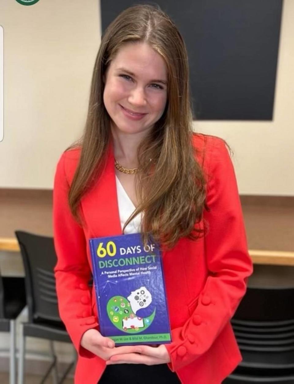 Keegan Lee holding “60 Days of Disconnect,” a book she co-wrote at the age of 16 with Elon University psychology professor Bilal Ghandour to write the book, which follows her two-month journey without social media. Photo courtesy of Keegan Lee