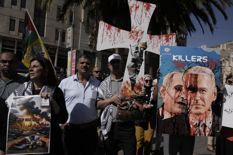Palestinians rally against the Israeli bombardment of the Gaza Strip in the West Bank city of Nablus on Thursday, October 26, 2023. The poster on the right shows Israeli Prime Minister Benjamin Netanyahu and US President Joe Biden. (AP Photo/Majdi Mohammed)