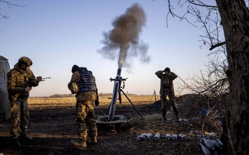 Ukrainian servicemen take cover as they fire a mortar load on the Donbas frontline - Anadolu Agency/Anadolu