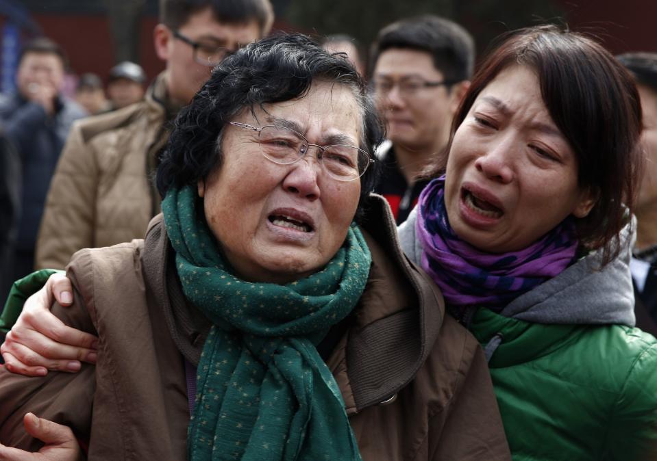Wang Guohui, mother of Li Zhi, a passenger of the missing flight MH370, cries with daughter-in-law Catherine Gang at a gathering in Beijing