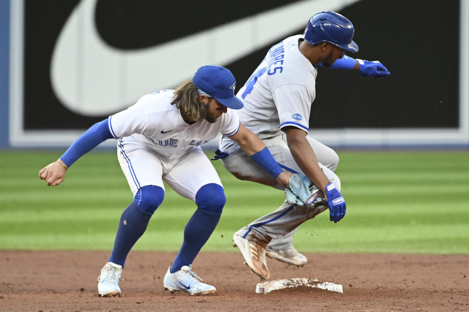 Toronto Blue Jays shortstop Bo Bichette, left, tags out Kansas City Royals' Edward Olivares on an attempted steal during the third inning of a baseball game Thursday, July 14, 2022, in Toronto. (Jon Blacker/The Canadian Press via AP)