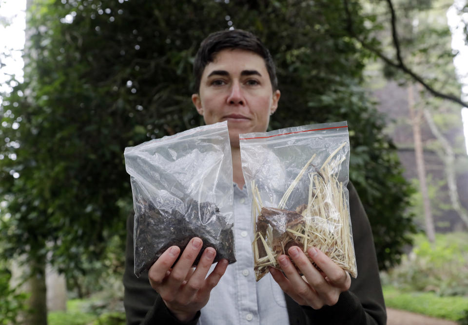 In this Friday, April 19, 2019, photo Katrina Spade, the founder and CEO of Recompose, displays a sample of the compost material left from the decomposition of a cow, left, and some of the combination of wood chips, alfalfa and straw used in the process, as she poses for a photo in Seattle. Washington is set to become the first state to allow the burial alternative known as "natural organic reduction," that turns a body into soil in a matter of weeks. (AP Photo/Elaine Thompson)