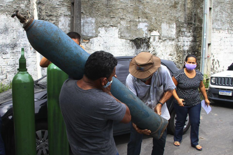 Family members of patients hospitalized with COVID-19 line up with empty oxygen tanks in an attempt to refill them, outside the Nitron da Amazonia company, in Manaus, Amazonas state, Brazil, Friday, Jan. 15, 2021. (AP Photo/Edmar Barros)