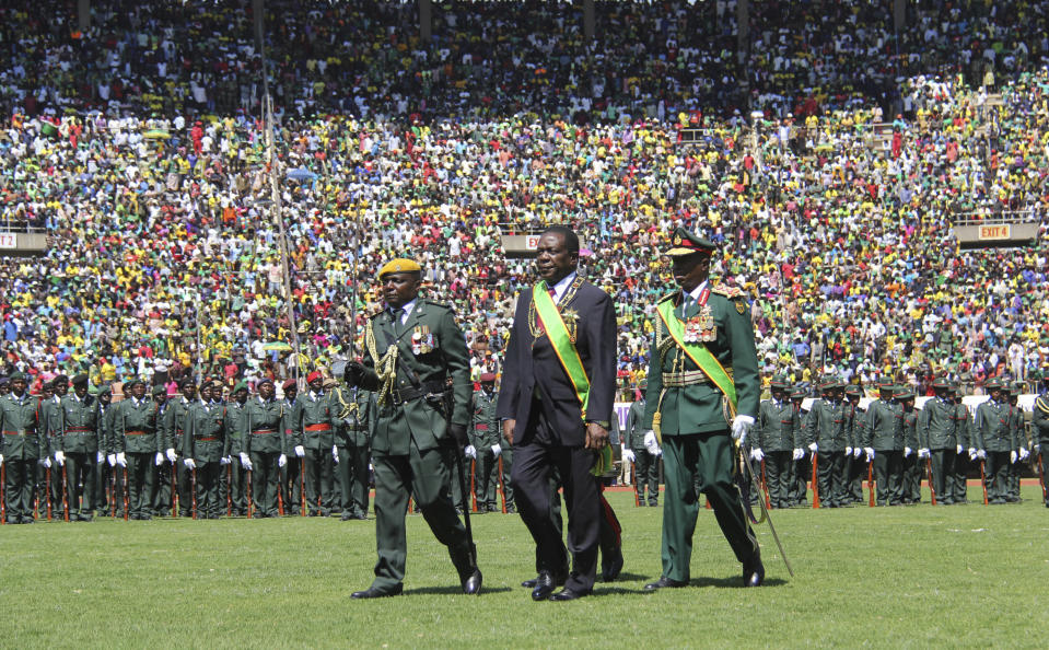 Zimbabwean President Emmerson Mnangagwa inspects the guard of honour during his inauguration ceremony at the National Sports Stadium in Harare, Sunday, Aug. 26, 2018. The Constitutional Court upheld Mnangagwa's narrow election win Friday, saying the opposition did not provide " sufficient and credible evidence" to back vote-rigging claims.(AP Photo/Tsvangirayi Mukwazhi)
