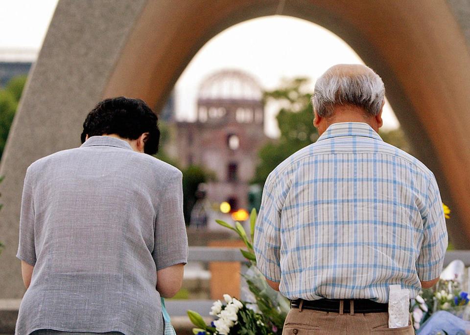 An elderly couple pray together before the memorial monument for atomic bomb victims in Hiroshima. <a href="https://www.gettyimages.com/detail/news-photo/an-elderly-couple-pray-together-before-the-memorial-news-photo/51146038?adppopup=true" rel="nofollow noopener" target="_blank" data-ylk="slk:Yoshikazu Tsuno/AFP via Getty Images;elm:context_link;itc:0;sec:content-canvas" class="link ">Yoshikazu Tsuno/AFP via Getty Images</a>