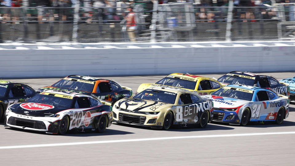 Christopher Bell (20), Kyle Busch (8), William Byron (24), Tyler Reddick (45), Joey Logano (22) and Ryan Blaney (12) head down the front straightaway after a caution flag during a NASCAR Cup Series auto race at Kansas Speedway in Kansas City, Kan., Sunday, Sept. 29, 2024. (AP Photo/Colin E. Braley)