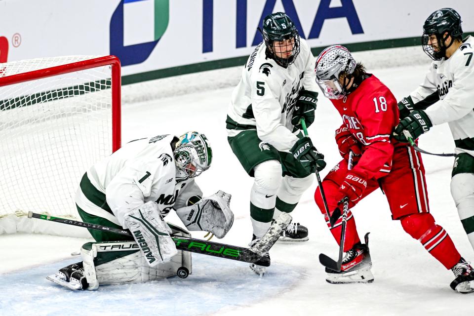 Michigan StateÕs goalie Trey Augustine, left, stops the puck as Ohio StateÕs Michael Gildon closes in during the first period of the Big Ten tournament game on Saturday, March 16, 2024, at Munn Arena in East Lansing.