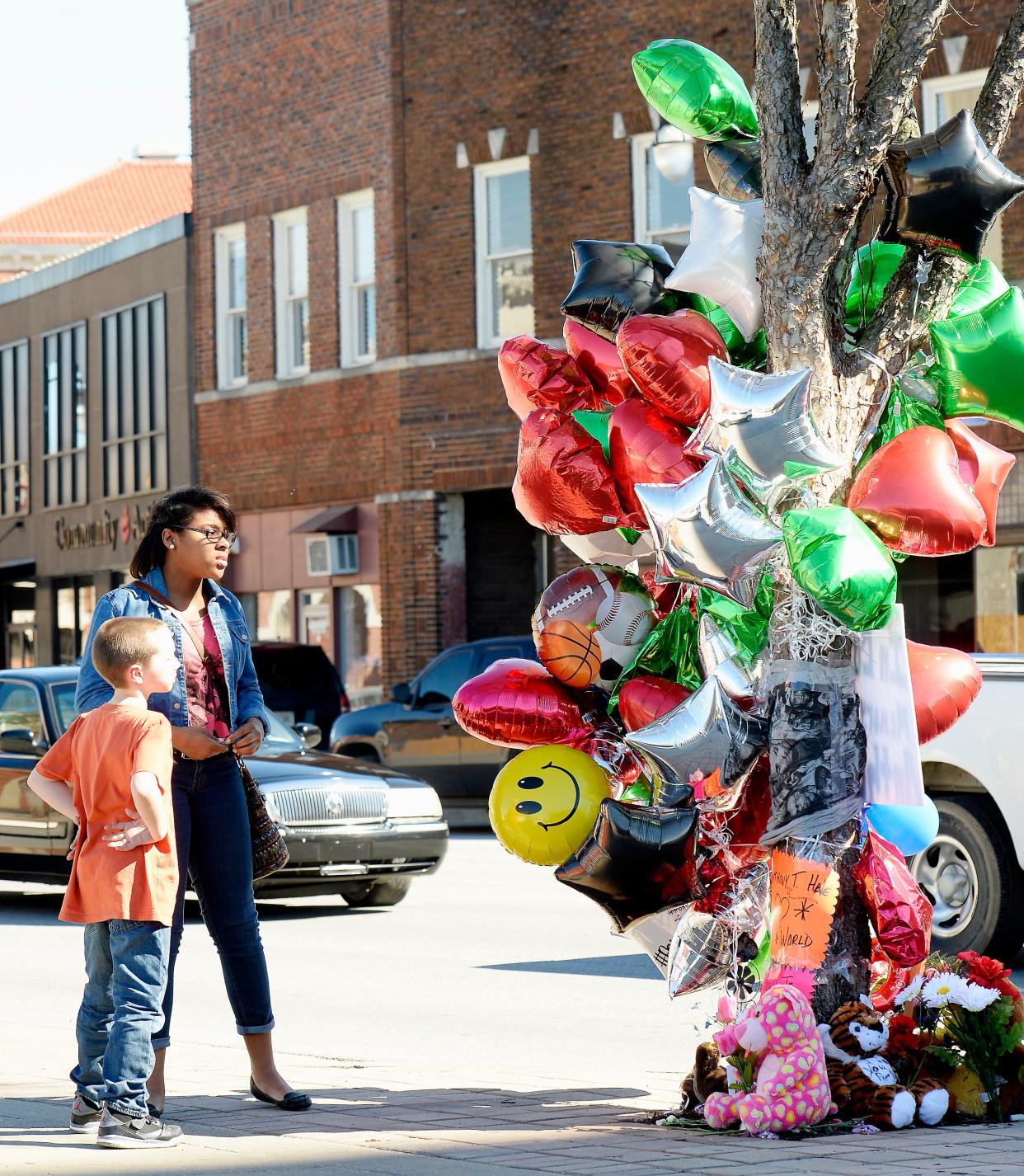 Brody Scott, left, and Jada Warren look March 16, 2015, at items left at a memorial for Anthony Hale Jr. at the intersection of Broad and Seventh streets in Gadsden,. Hale, 17, a Gadsden City High student, was fatally shot two days earlier as he left a party at a downtown lounge.