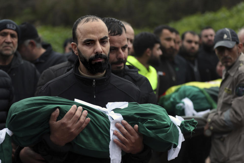 Jalal Mohsin carries the body of his child Amir, who was killed in an Israeli strike last night, during his funeral procession in Qantara village, south Lebanon, Thursday, Feb. 15, 2024. The civilian death toll from two Israeli airstrikes in Lebanon has risen to 10, Lebanese state media reported Thursday, making the previous day the deadliest in more than four months of cross-border exchanges. (AP Photo/Mohammed Zaatari)