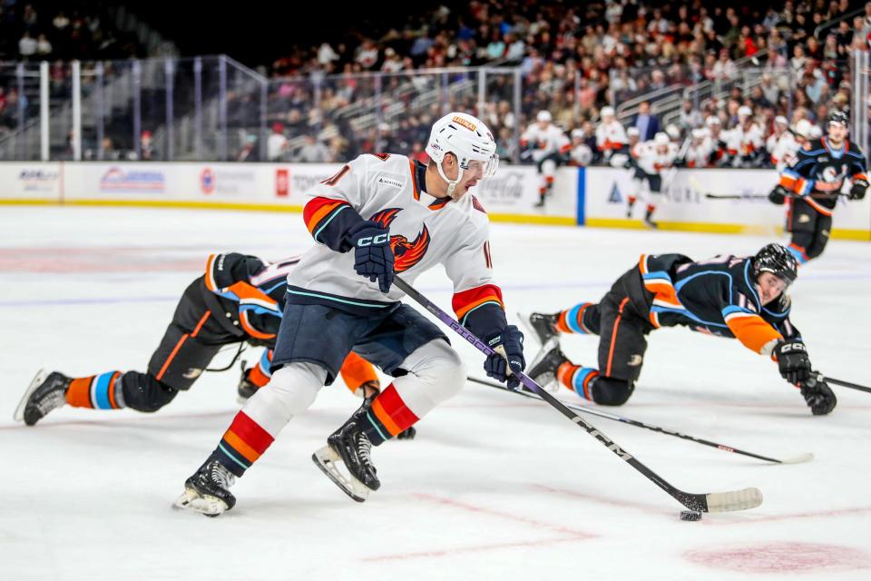 Firebirds forward Luke Henman (10) skates by as two San Diego Gulls stretch to defend during the game at Acrisure Arena in Palm Desert, Calif., on Wed., Nov. 8, 2023.