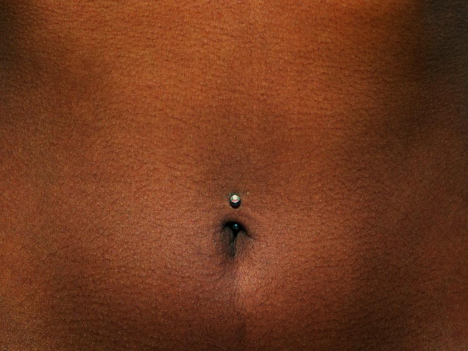silver jewelry in upper portion on belly button on stomach