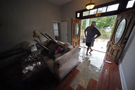 Danny Gonzales, walks in his flooded house as water recedes, after Tropical Storm Claudette passed through, in Slidell, La., Saturday, June 19, 2021. The National Hurricane Center declared Claudette organized enough to qualify as a named storm early Saturday, well after the storm's center of circulation had come ashore southwest of New Orleans.(AP Photo/Gerald Herbert)