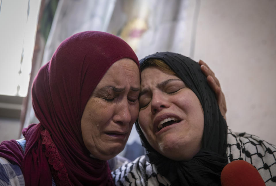 Palestinian Nevin Abu Arab, 49, right, cries with a relative mourner during the funeral of her son Ahmed Jamil Fahed, in the West Bank refugee camp of al-Amari, Ramallah, Tuesday, May 25, 2021. Fahed was shot and killed by undercover Israeli forces early Tuesday near Ramallah, according to the Palestinian Authority's official Wafa news agency. (AP Photo/Nasser Nasser)