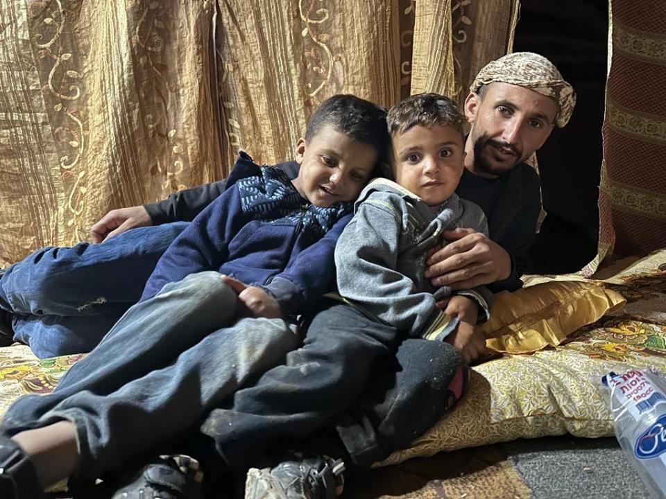 A Bedouin Palestinian man sits with his children in a tent on a neighbor's property in the West Bank, Nov. 11, 2023, after hundreds of members of their community were allegedly forced from their homes in the village of Wadi al Seeq by Israeli settlers. / Credit: CBS News/Agnes Reau