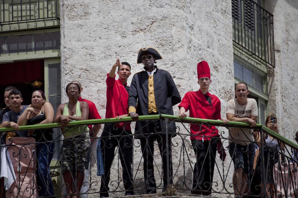 Workers at the La Moneda Cubana restaurant stand on a balcony to watch the arrival of U.S. singer Beyonce and her husband, rapper Jay-Z, in Old Havana, Cuba, Thursday, April 4, 2013. R&B's power couple is in Havana on their fifth wedding anniversary. (AP Photo/Ramon Espinosa)