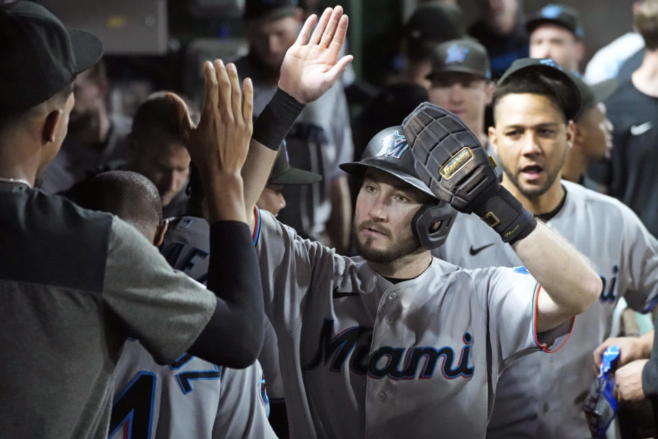 Miami Marlins' Garrett Hampson, center, celebrates in the dugout after scoring on a sacrifice fly by Josh Bell off Pittsburgh Pirates relief pitcher Dauri Moreta during the sixth inning of a baseball game in Pittsburgh, Saturday, Sept. 30, 2023. (AP Photo/Gene J. Puskar)