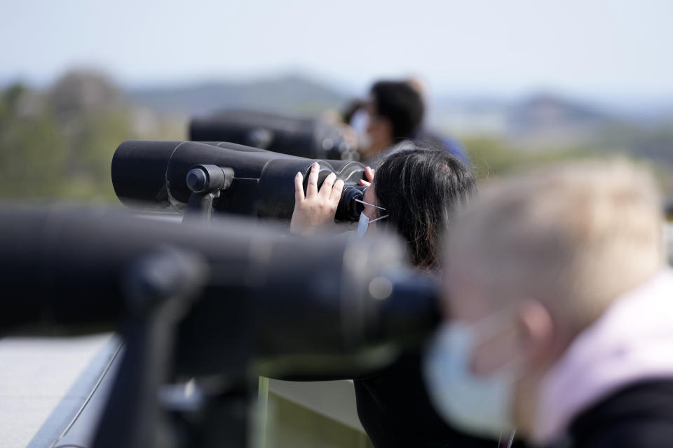 Visitors use binoculars to see the North Korean side from the unification observatory in Paju, South Korea, Friday, April 15, 2022. North Korea is marking a key state anniversary Friday with calls for stronger loyalty to leader Kim Jong Un, but there was no word on an expected military parade to display new weapons amid heightened animosities with the United States. (AP Photo/Lee Jin-man)