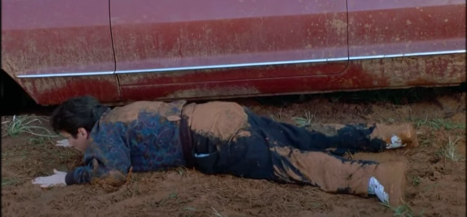 A man lying in the mud after falling