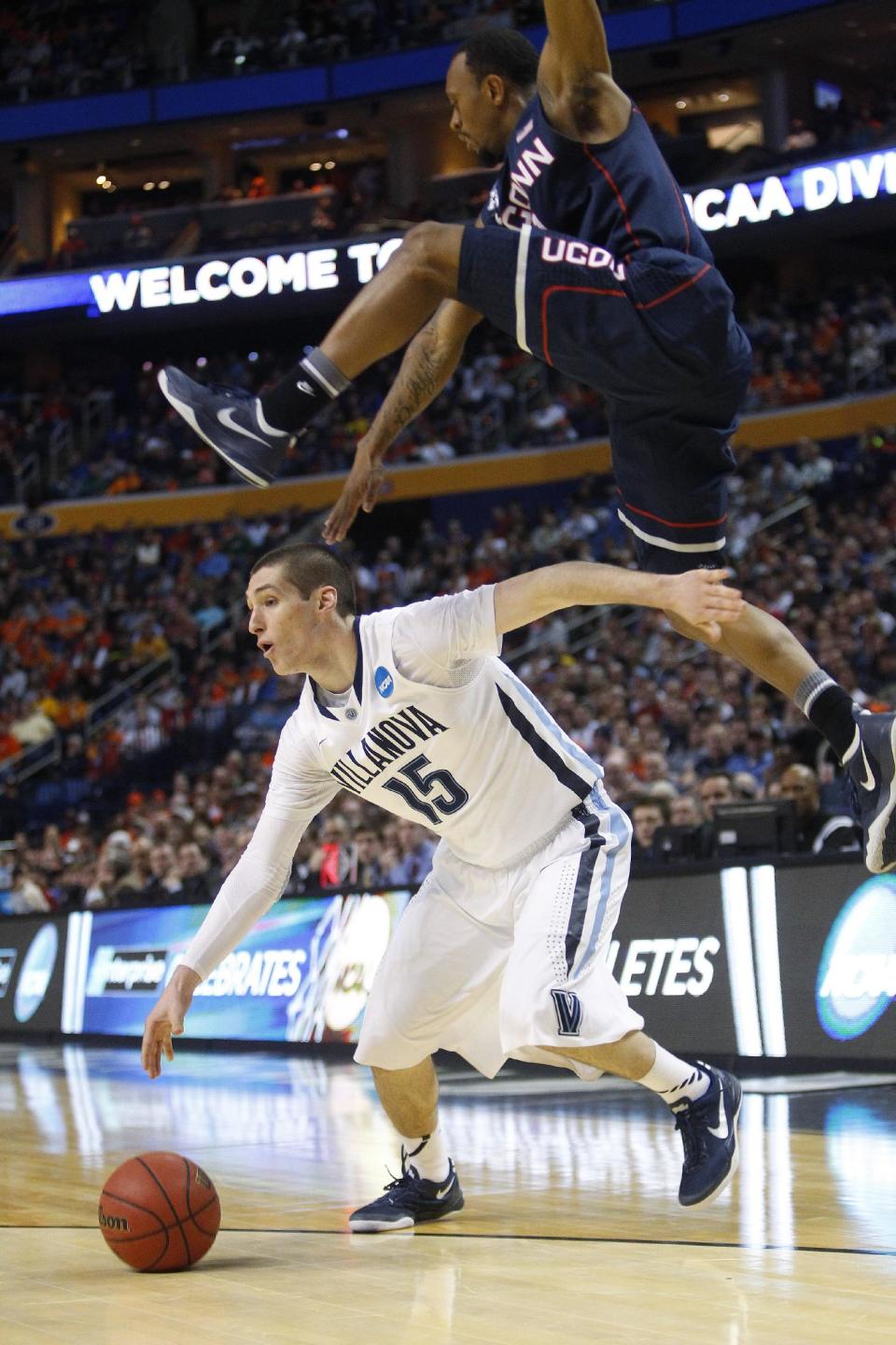Villanova's Ryan Arcidiacono (15) drives under Connecticut's Ryan Boatright during the first half of a third-round game in the NCAA men's college basketball tournament in Buffalo, N.Y., Saturday, March 22, 2014. (AP Photo/Bill Wippert)