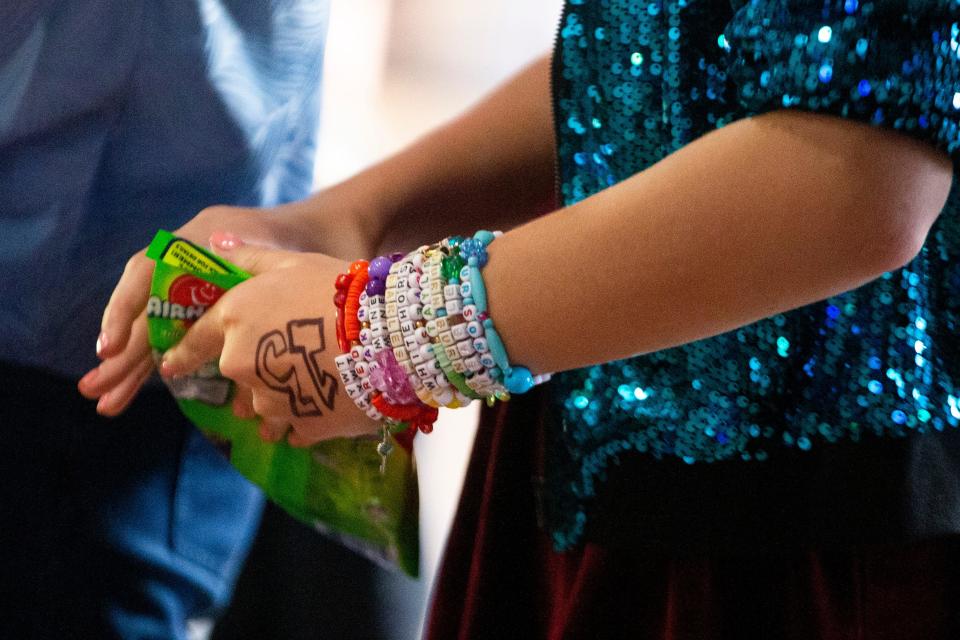 A Taylor Swift fan with bracelets and a “13” on her hand gets candy from the concession stand before going in to see “Taylor Swift: The Eras Tour” at Malco Paradiso Cinema Grill and IMAX in Memphis, Tenn., on Saturday, October 14, 2023.