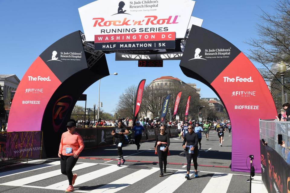 82-year-old runner Wilma King and her daughter pass under a large sign marking the course for the Rock n Roll half marathon  in Washington DC