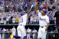 Texas Rangers' Adolis Garcia (53) and third base coach Tony Beasley, right, celebrate Garcia's home run during the sixth inning of the team's baseball game against the Chicago Cubs, Thursday, March 28, 2024 in Arlington, Texas. (AP Photo/Gareth Patterson)