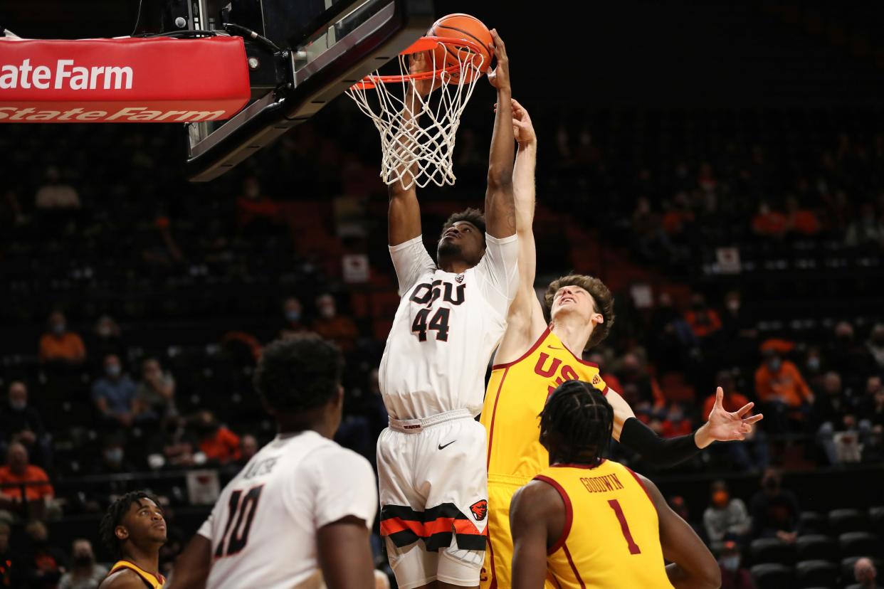 Oregon State forward Ahmad Rand dunks as Southern California guard Drew Peterson tries to block the shot during the second half of an NCAA college basketball game Thursday, Feb. 24, 2022, in Corvallis, Ore. Southern California won 94-91. (AP Photo/Amanda Loman)