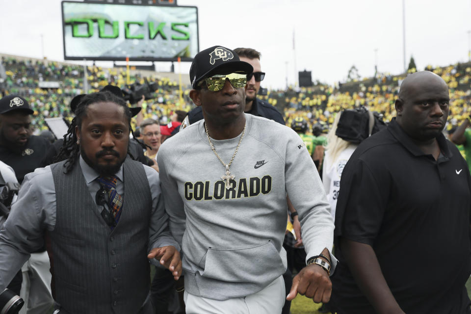 Colorado head coach Deion Sanders, center, exits the field following an NCAA football game against Oregon, Saturday, Sept. 23, 2023, in Eugene, Ore. Oregon won 42-6. (AP Photo/Amanda Loman)