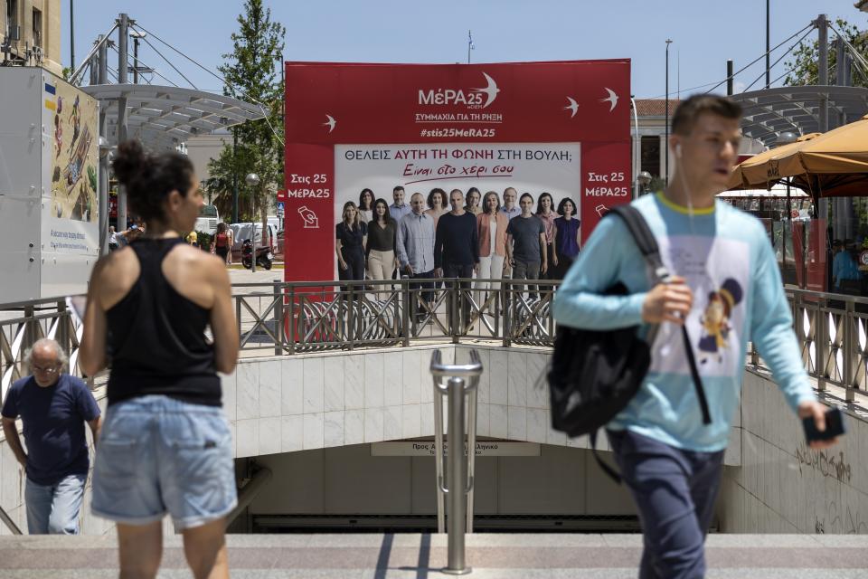 People walk past an election kiosk of the European Realistic Disobedience Front (MeRA25) party, in Athens, Greece, Thursday, June 22, 2023. Three far-right and two far-left, could conceivably cross the 3% parliamentary entry threshold in Sunday's elections, despite a swing back to mainstream politicians as the scars of Greece's 10-year financial crisis gradually heal. (AP Photo/Yorgos Karahalis)