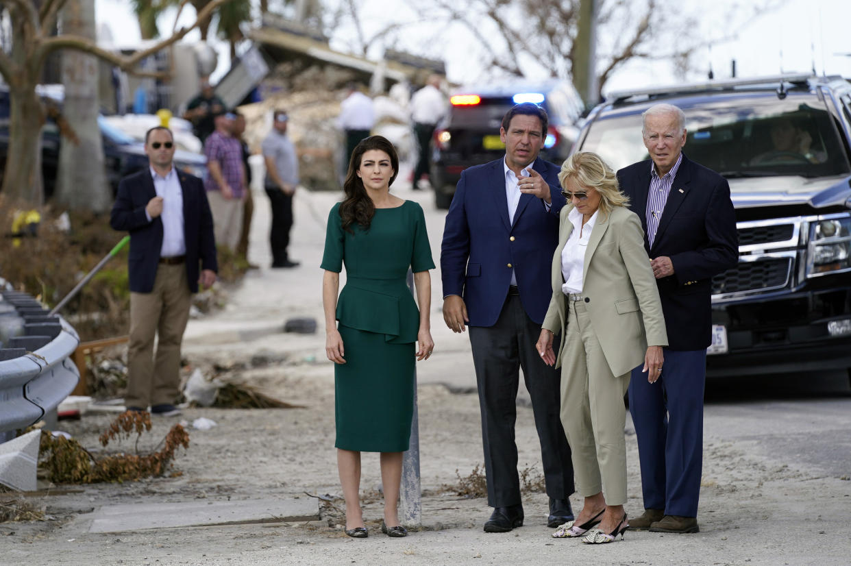 President Biden and his wife, Jill, huddle with Florida Gov. Ron DeSantis and his wife, Casey.