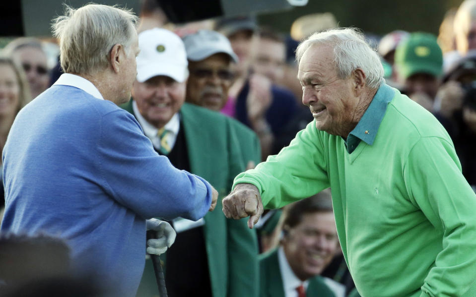 Arnold Palmer touches fists with Jack Nicklaus after hitting his ceremonial drive on the first tee during the first round of the Masters golf tournament Thursday, April 10, 2014, in Augusta, Ga.(AP Photo/Charlie Riedel)