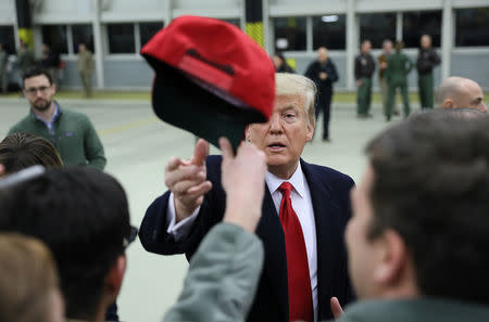 U.S. President Donald Trump receives a cap while visiting U.S. troops at Ramstein Air Force Base, Germany, December 27, 2018. REUTERS/Jonathan Ernst