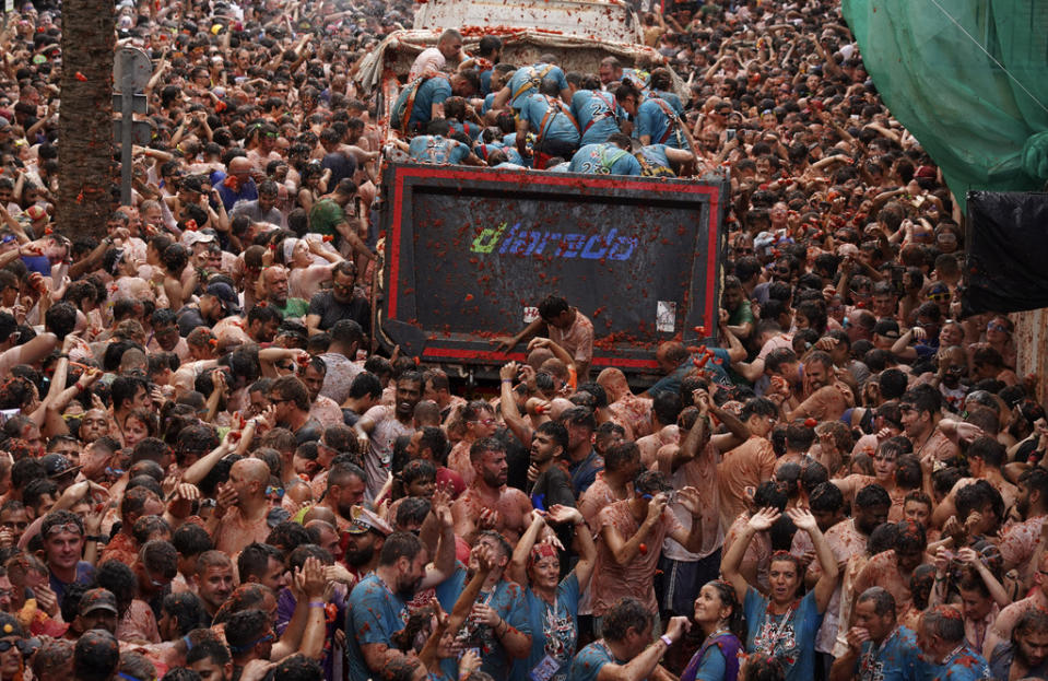 Revellers throw tomatoes at each other during the annual “Tomatina” tomato fight fiesta, in the village of Bunol near Valencia, Spain, Wednesday, Aug. 30, 2023. Thousands gather in this eastern Spanish town for the annual street tomato battle that leaves the streets and participants drenched in red pulp from 120,000 kilos of tomatoes. (AP Photo/Alberto Saiz)