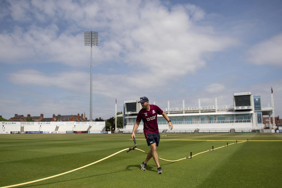 Head groundsman Craig Harvey tends to the outfield at the County Ground, home of Northamptonshire County Cricket Club, in Northampton, England, Wednesday May 27, 2020. Professional cricket teams are waiting to be given the green light to return to competitive sport as the country comes out of lockdown due to the highly contagious coronavirus pandemic. (Joe Giddens / PA via AP)
