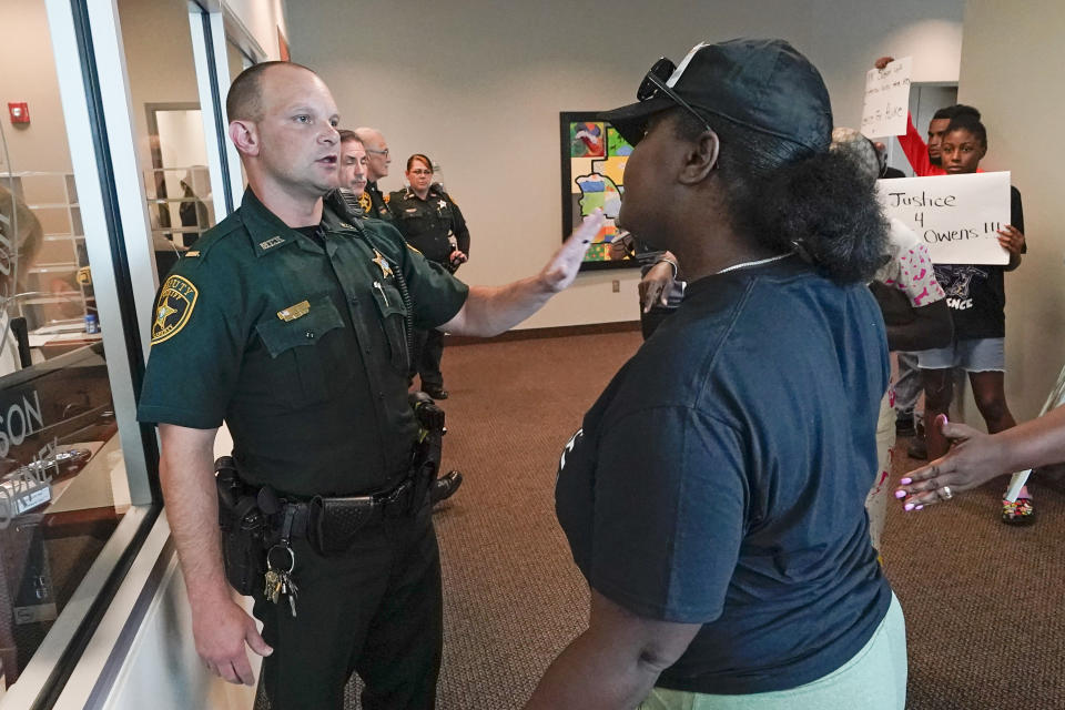 A protester, right, confronts a Marion County sheriff deputy at the Marion County Courthouse, Tuesday, June 6, 2023, in Ocala, demanding the arrest of a woman who shot and killed Ajike Owens, a 35-year-old mother of four, last Friday night, June 2. Authorities came under intense pressure Tuesday to bring charges against a white woman who killed Owens, a Black neighbor, on her front doorstep, as they navigated Florida’s divisive stand your ground law that provides considerable leeway to the suspect in making a claim of self defense. (AP Photo/John Raoux)