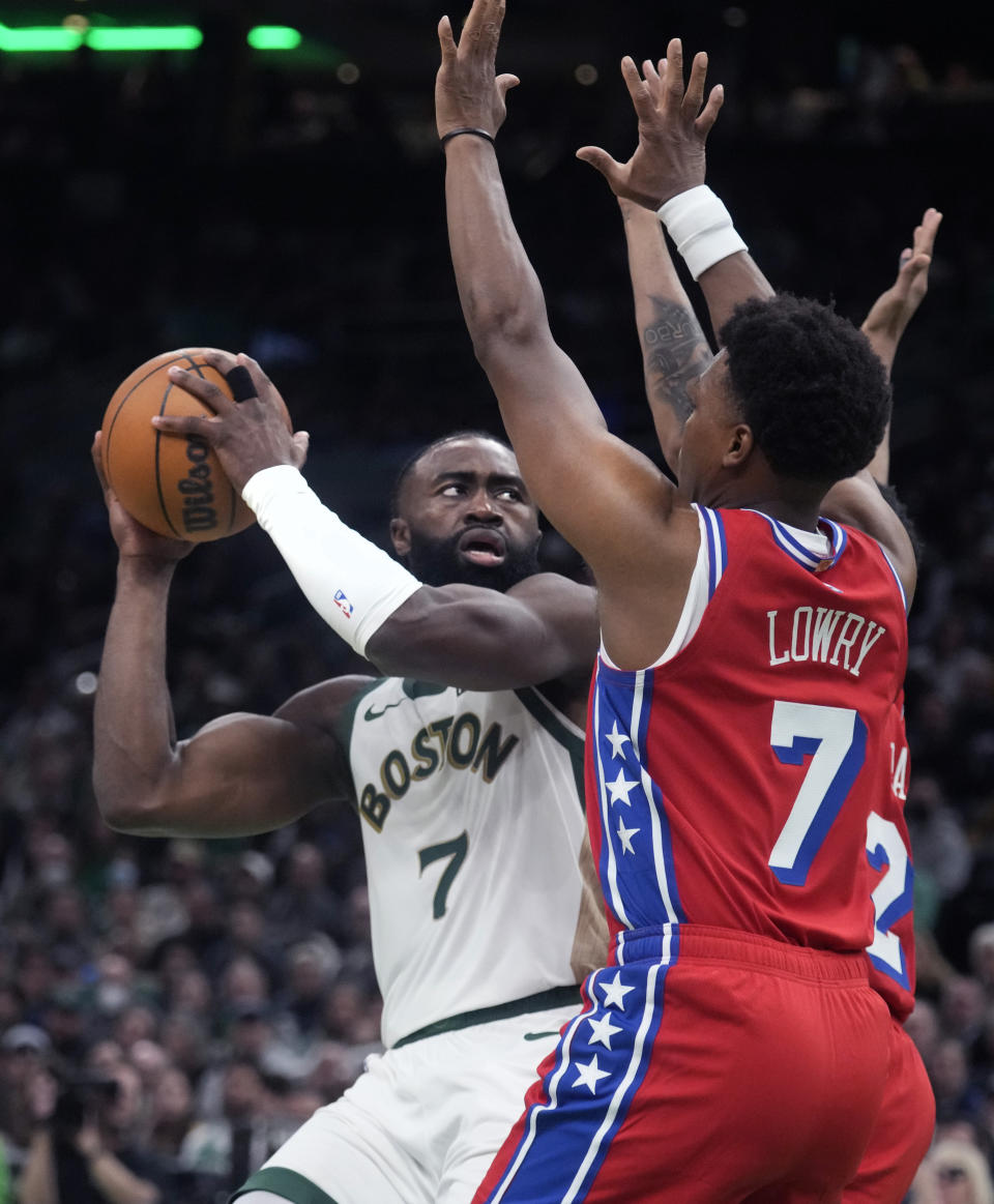 Boston Celtics guard Jaylen Brown, left, is covered by Philadelphia 76ers guard Kyle Lowry, right, during the first half of an NBA basketball game, Tuesday, Feb. 27, 2024, in Boston. (AP Photo/Charles Krupa)