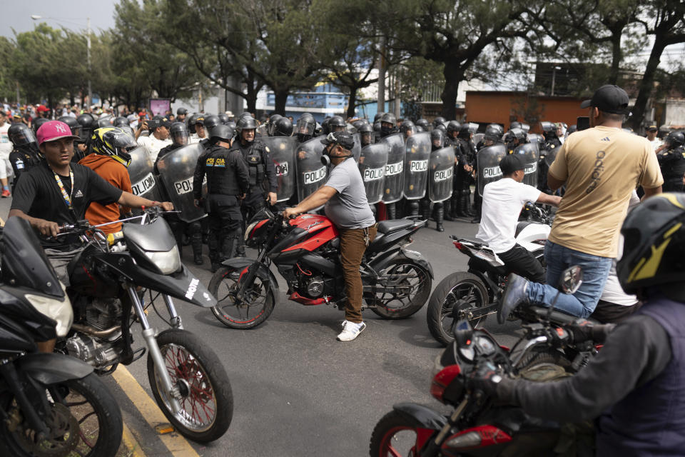 Demonstrators surround the police forcing them to retreat during a national strike, in Guatemala City, Tuesday, Oct. 10, 2023. People are protesting to support President-elect Bernardo Arévalo after Guatemala's highest court upheld a move by prosecutors to suspend his political party over alleged voter registration fraud. (AP Photo/Santiago Billy)