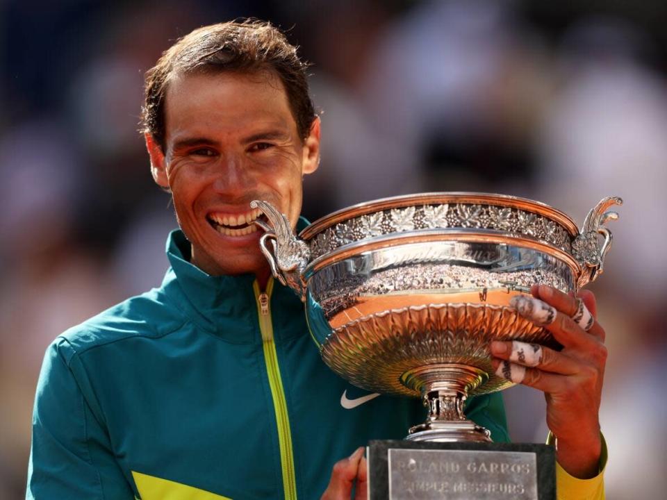 Rafael Nadal of Spain bites the trophy after defeating Casper Ruud of Norway during the men's singles final match at the 2022 French Open on Sunday at Roland Garros in Paris. ( Clive Brunskill/Getty Images - image credit)