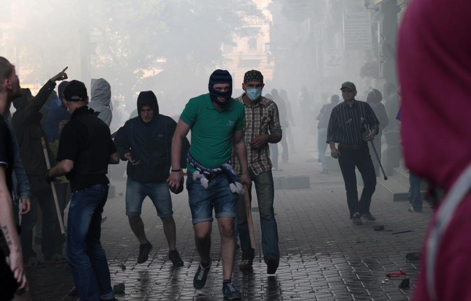 A Ukrainian government supporter holds a stone and a stick during a clash with pro-Russians in the Black Sea port of Odessa, Ukraine, Friday, May 2, 2014. A clash broke out late Friday between pro-Russians and government supporters in Odessa, on the Black Sea coast some 550 kilometers (330 miles) from the turmoil in the east. Odessa had remained largely untroubled by unrest since the February toppling of pro-Russia President Viktor Yanukovych, which ignited tensions in the east. (AP Photo/Sergei Poliakov)