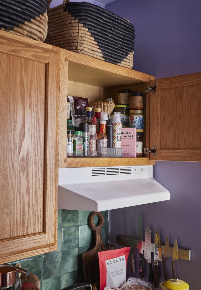 Kitchen cabinet opened to reveal spice drawer.